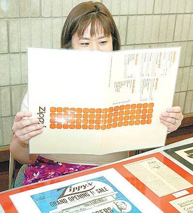 A designer holding the new orange square Zippy's branding