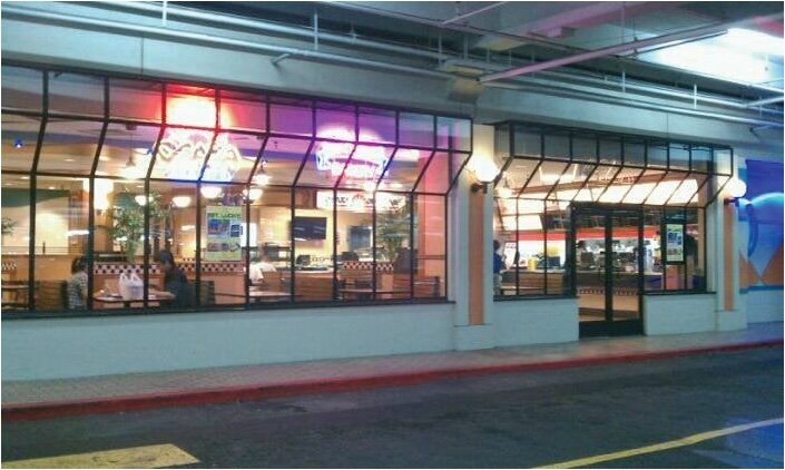 The lit glass storefront of Zippy's Ala Moana at night