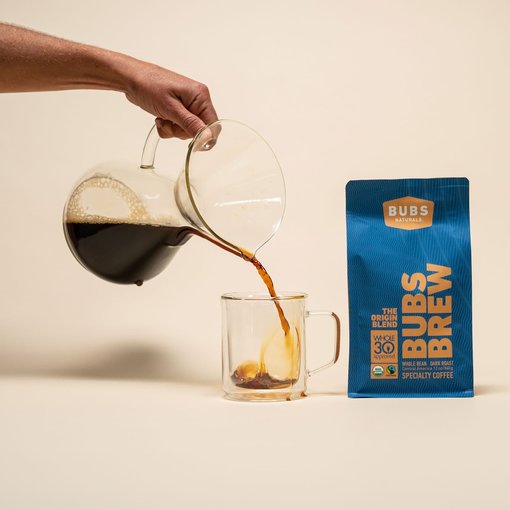 A cup of BUBS Brew dark-roast origin coffee being poured