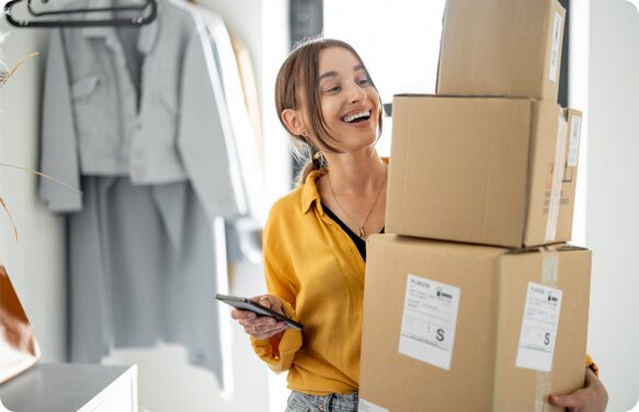 Female with 3 boxes in her hand and a phone in her other hand