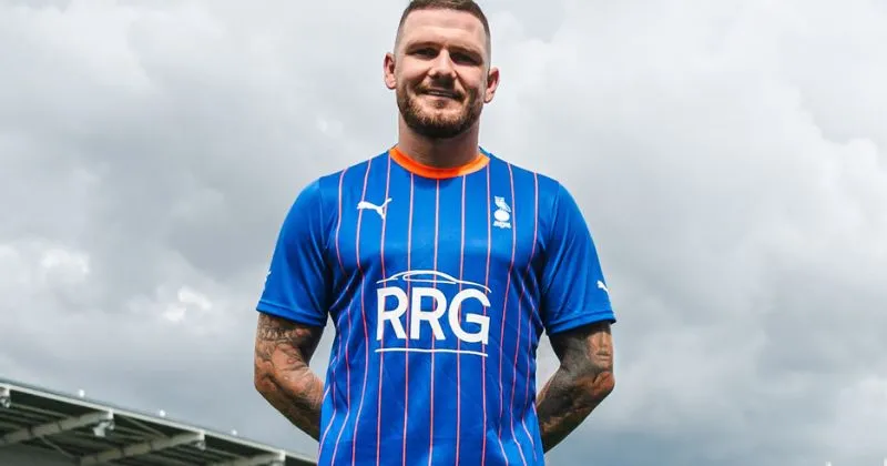 player wearing oldham athletic 2023-24 home shirt in blue and orange
