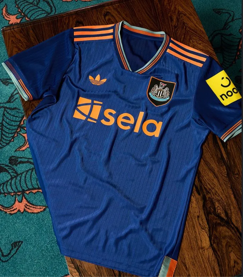 blue 2025 newcastle third kit with orange details 