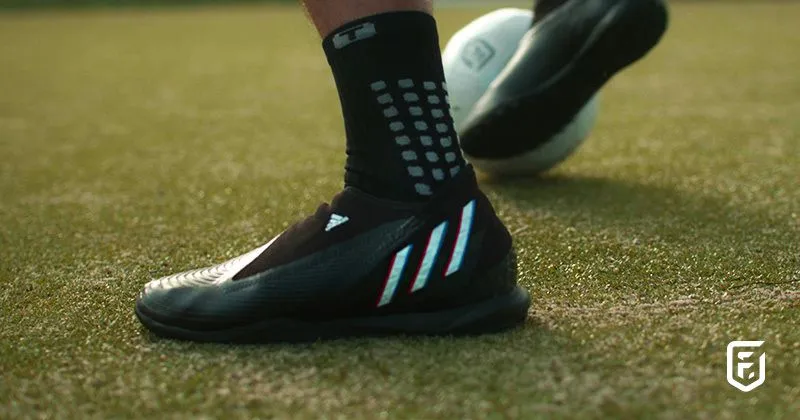 someone playing football on astro turf in black football boots