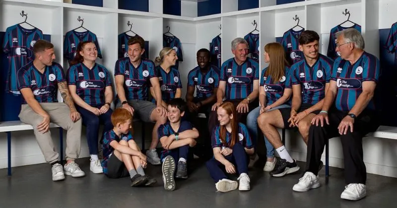 fans and players wearing hartlepool united 2023-24 away shirt in blue and teal