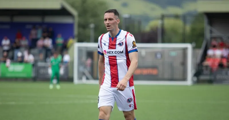 player wearing dorking wanderers 2023-24 home shirt in white and red