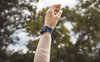 hand wearing the Starry Night watchband with trees in the background