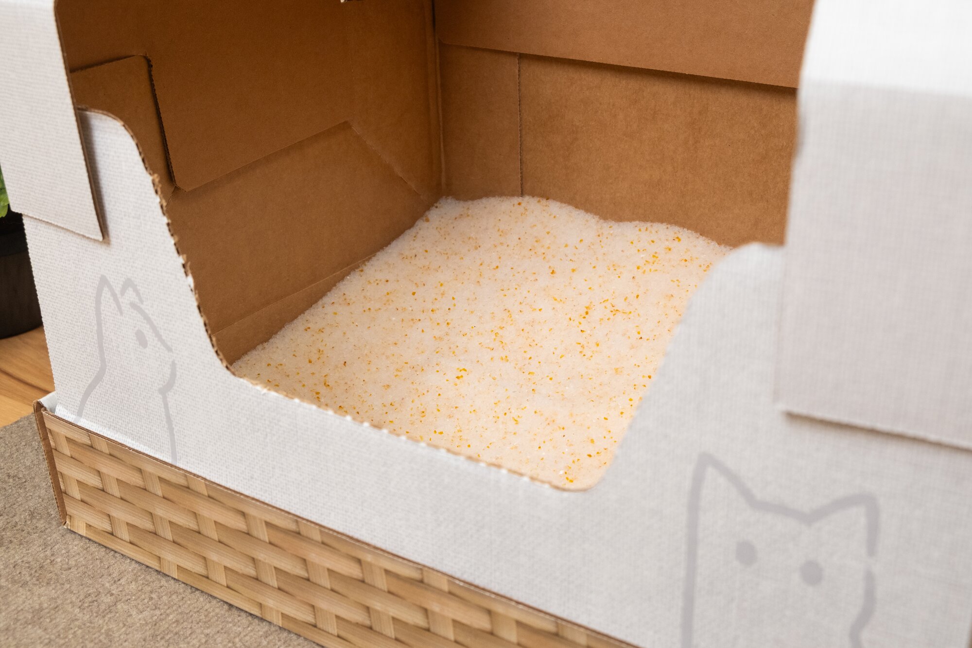 A person scooping their Kitty Poo Club Litter Box with a turquoise blue scoop.