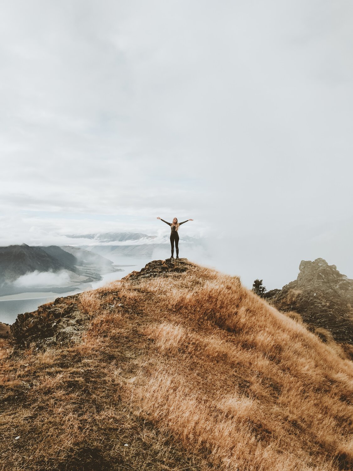 A victorious woman on top of a hill