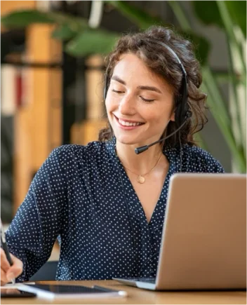service client, femme face a un ordinateur avec un casque micro, en train de prendre des notes.
