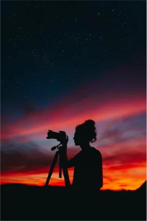 Femme photographe avec un coucher de soleil 