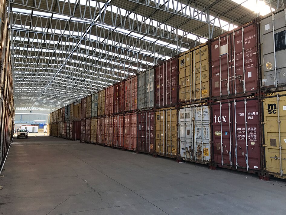 A car parked next to a stack of shipping containers