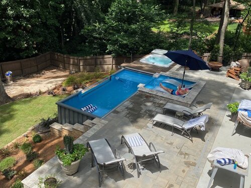 A backyard with a shipping container pool