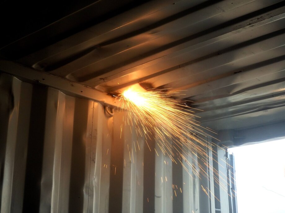 An opening being cut into the roof of a shipping container.
