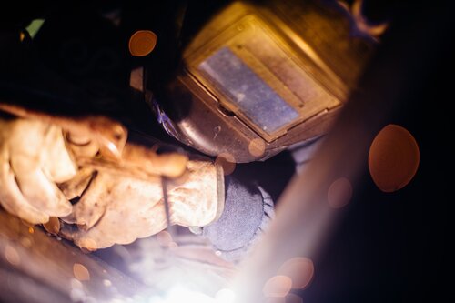 A welder working on a shipping container