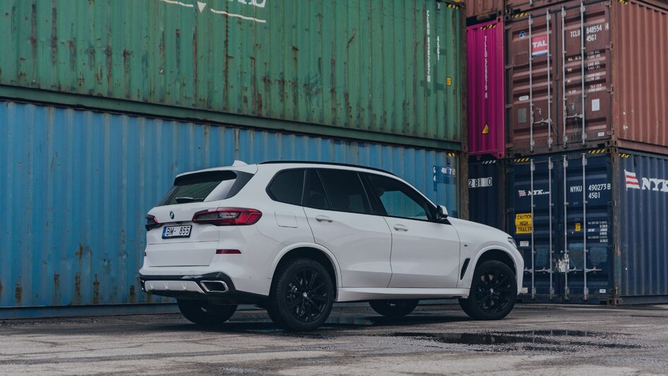 A car parked next to a stack of shipping containers