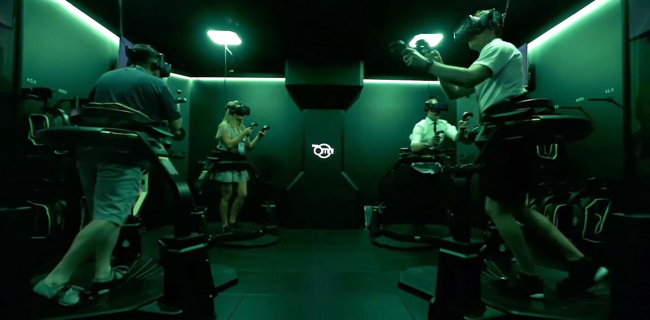 Four players playing VR games inside of an Omni Arena.