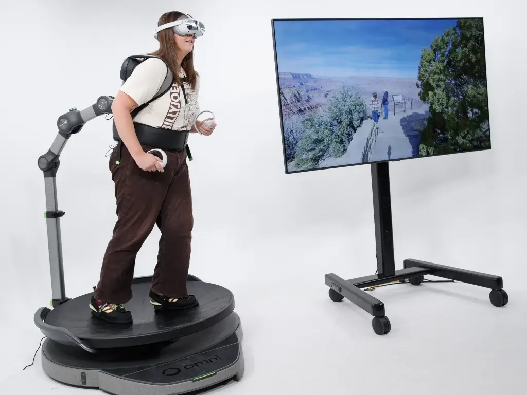 Woman walking on Omni One in a room with a desk and office chair.