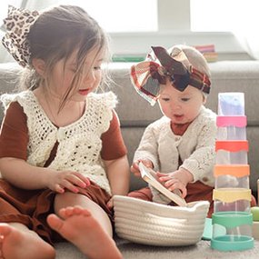 Siblings playing with Lovevery drip drop cups