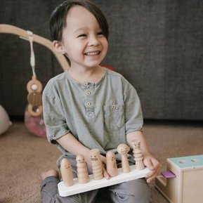 Child playing with the Lovevery Wooden Camper With Locking Doors 