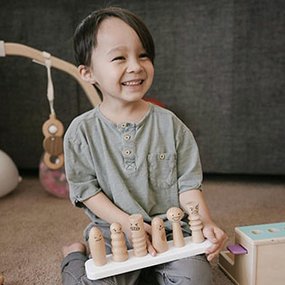 Boy playing with Lovevery emotion doll set