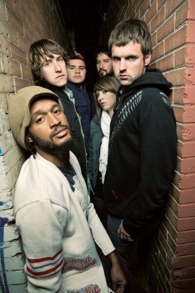 Flobots leaning against brick wall