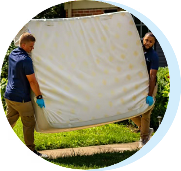 delivery team hauling away an old mattress