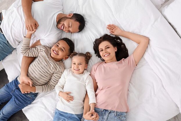 family on bed smiling