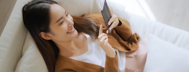 woman on bed with mobile phone