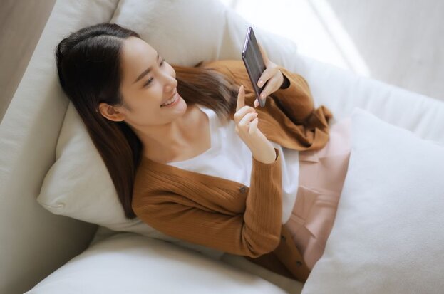 woman on bed with mobile phone