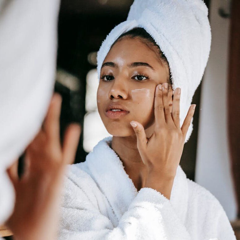 Woman putting on face cream.