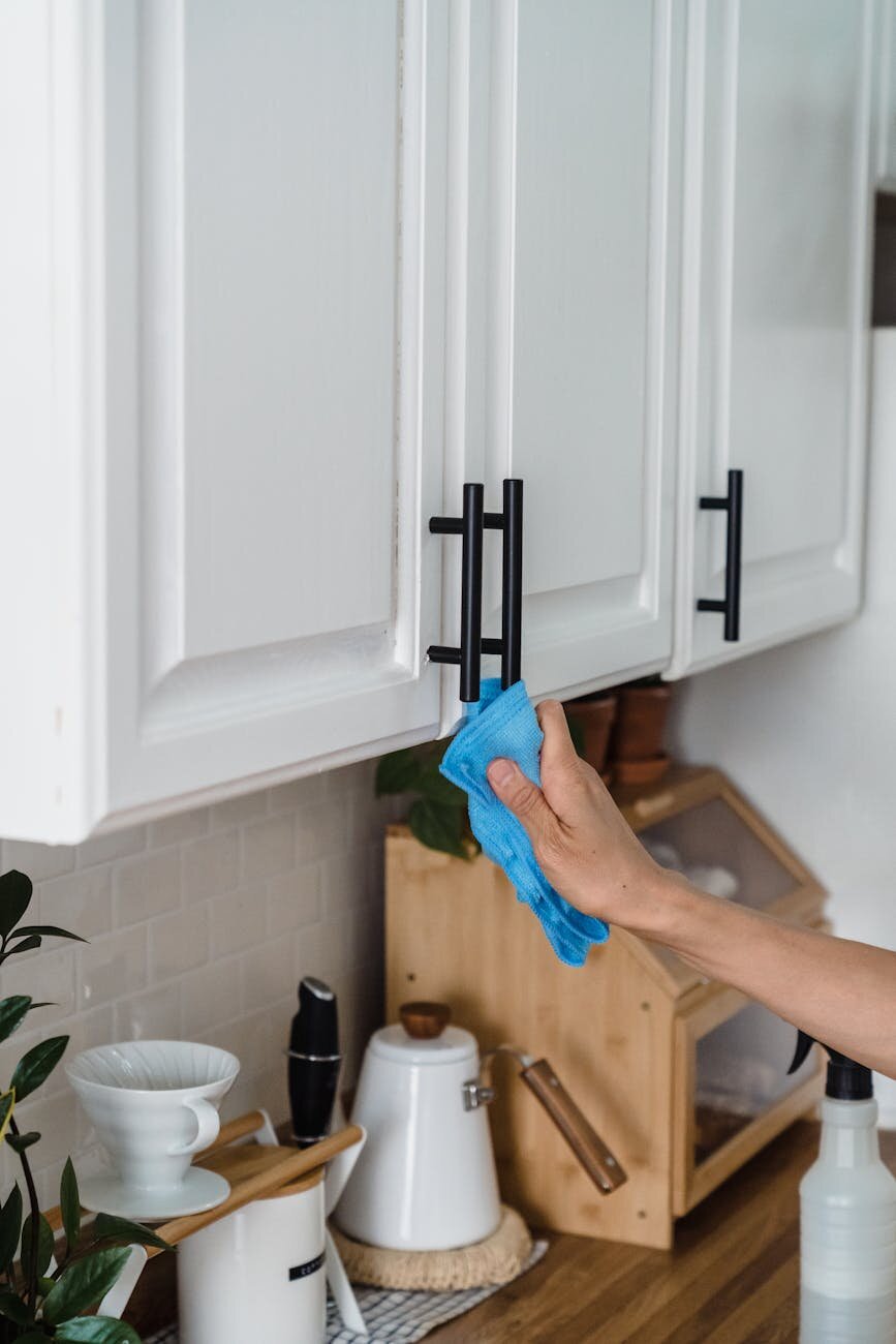 Someone cleaning kitchen cabinets.