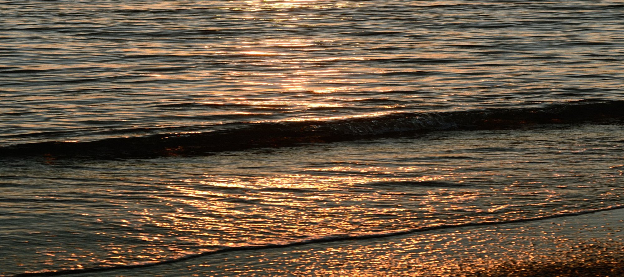 Sunset on calm, rippling ocean waves