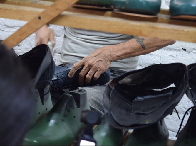Artesano trabajando en la elaboración de calzado dentro de un taller, representando los oficios mexicanos y la tradición zapatera.