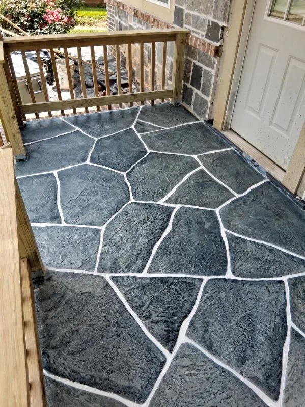 Dark hand-carved flagstone concrete porch with bright grout lines