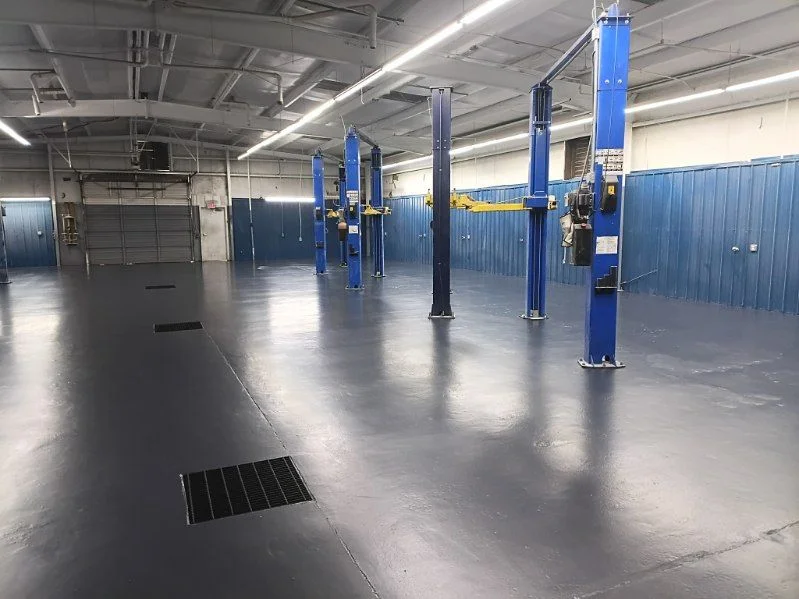 Seamless dark epoxy floor in an automotive service shop