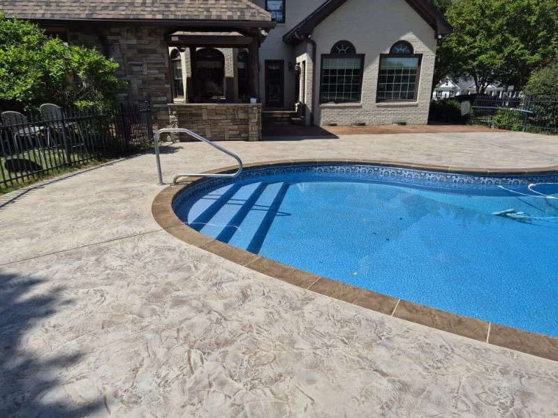 Textured concrete pool deck with a contrasting coping border