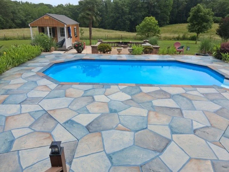 Blue-gray flagstone-pattern concrete pool deck surrounding a swimming pool