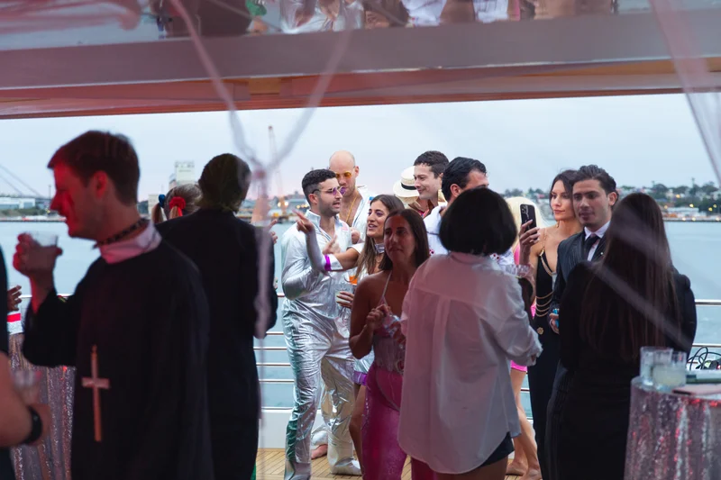 Halloween party crowd on a yacht with harbour backdrop