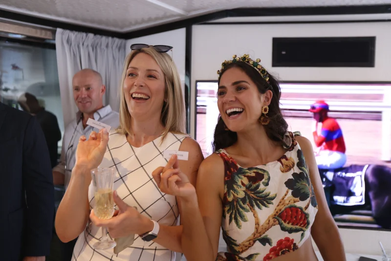Corporate guests enjoying Melbourne Cup sweepstakes on board