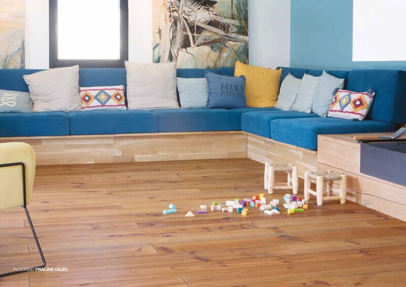 FP Bois Praline Oiled solid Bordeaux pine flooring installed in a bright family living room with blue corner sofa
