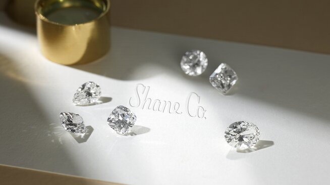 A loose round diamond held in tweezers