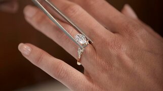 Hand holding a diamond engagement ring