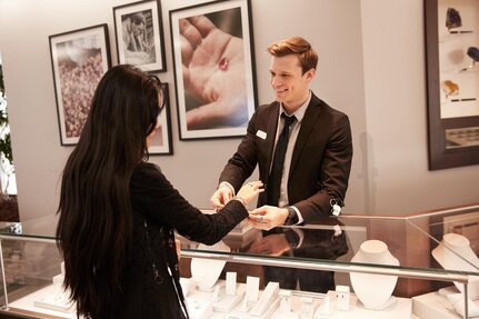 Jeweller showing bracelets to a customer in store
