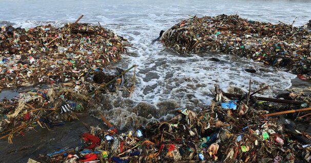 Image shows a coastal areas covered in plastic pollution - which is what happens without your partnership