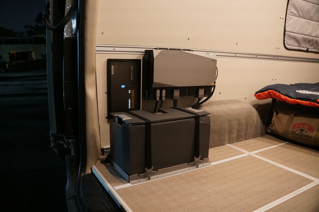 Two men are working in the front of the conversion van build. They are using the swivel seats up front and the Fenton Folding Chair.