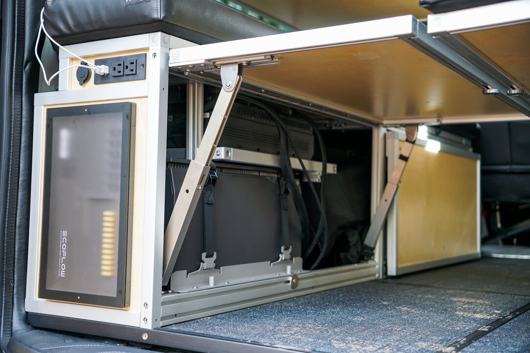 The conversion van electrical power system is sitting in the rear driver side of the vehicle. It is an EcoFlow power 5kwh power kit, and is integrated into the New Way Van Life bed system.