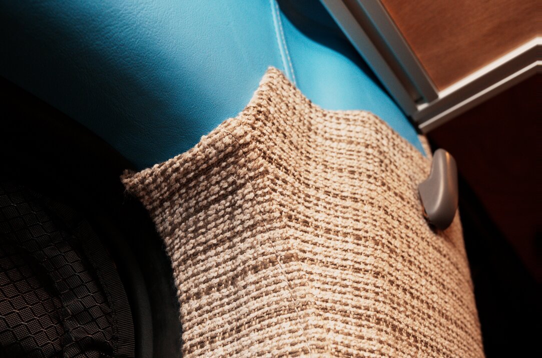 Close-up of the cloth fabric upholstery and blue headliner in the conversion van.