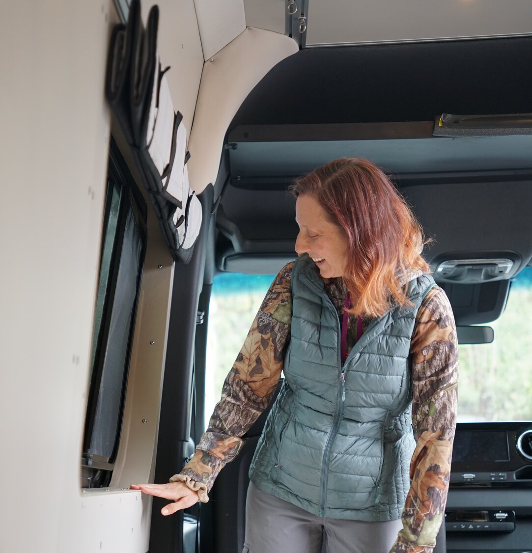 Camper van kitchen faucet spraying out the slider door of the 144 conversion van.