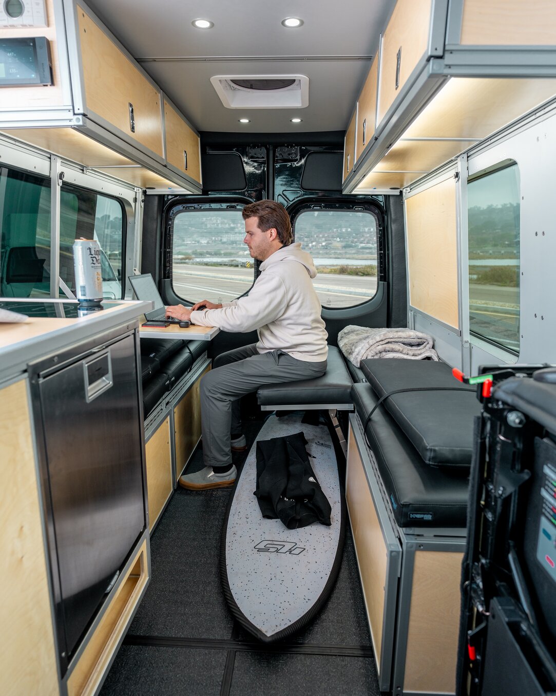 The rear of the van is turned into a mobile workspace. Using the bed flip up on the driver's side and the folding desk on the driver's side.