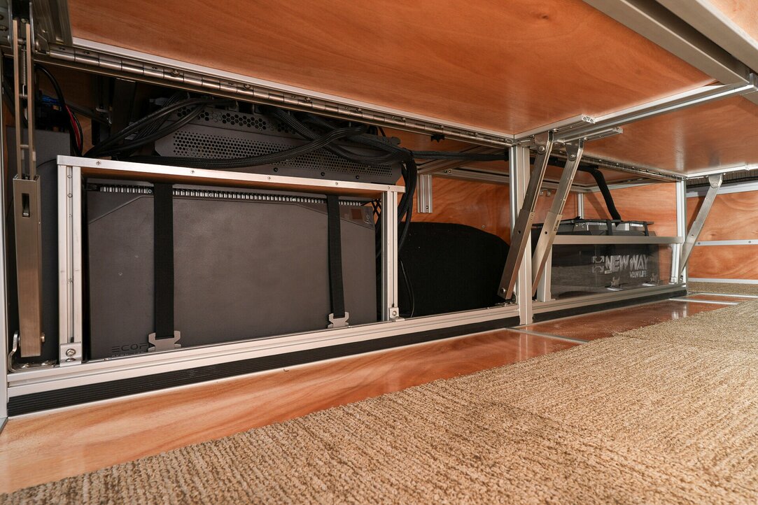 Discover the EcoFlow Power Kit showcased beneath the bed system, featuring 10 kWh of Lithium Iron Phosphate (LFP) batteries securely stored behind the retention lips and bed flip-ups.
